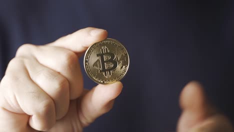 Bitcoin.-Man-offers-bitcoin-in-hand.